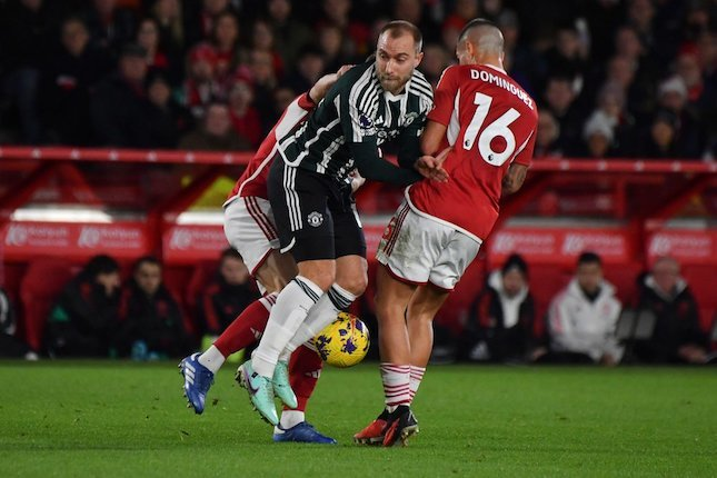Duel Christian Eriksen dan Nicolas Dominguez dalam laga Nottingham Forest vs Manchester United pada pekan ke-20 Premier League 2023/2024, Minggu (31/12/2023) dini hari WIB. (c) AP Photo/Rui Vieira